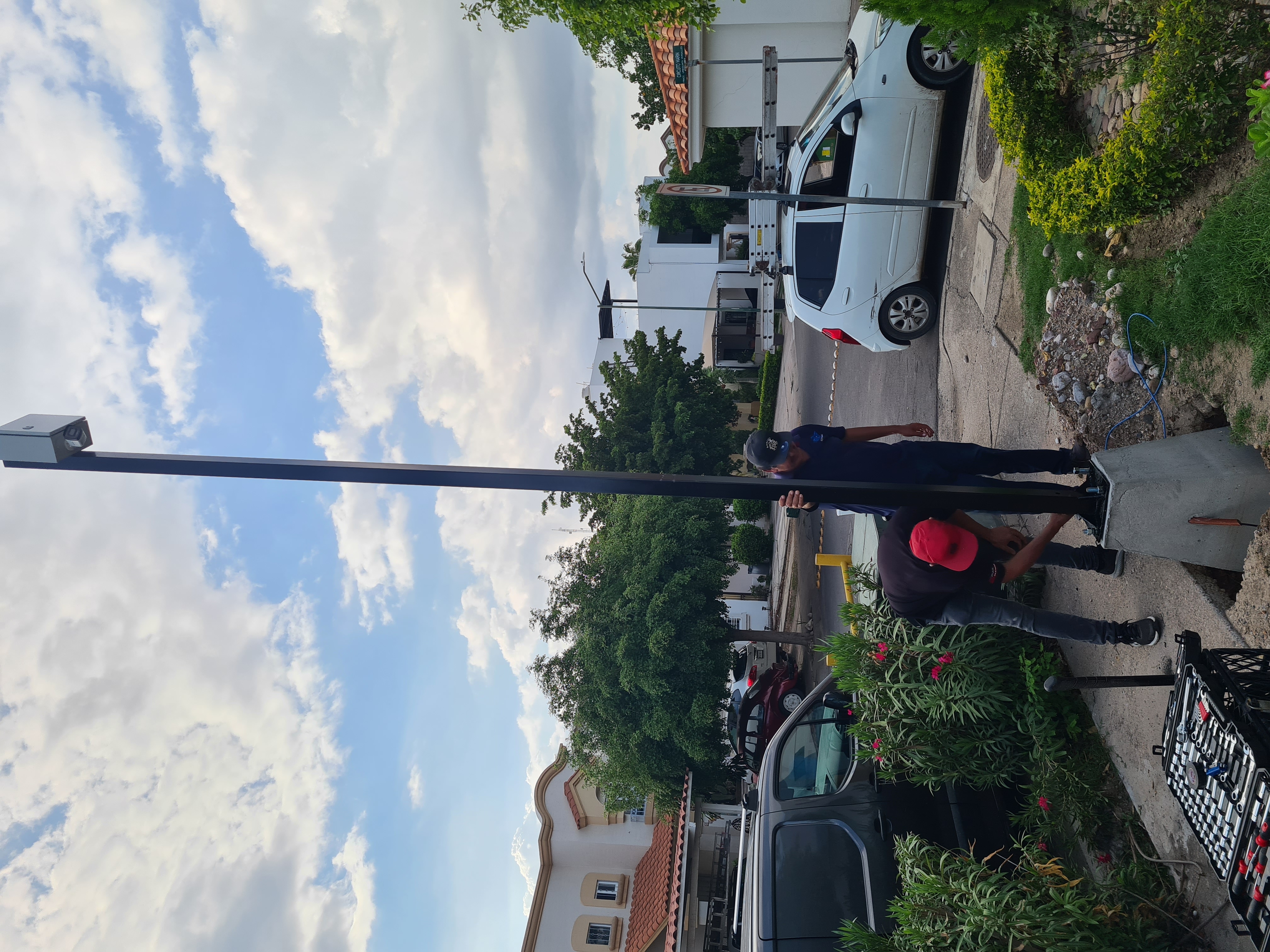 Técnicos instalando poste para cámara de videovigilancia