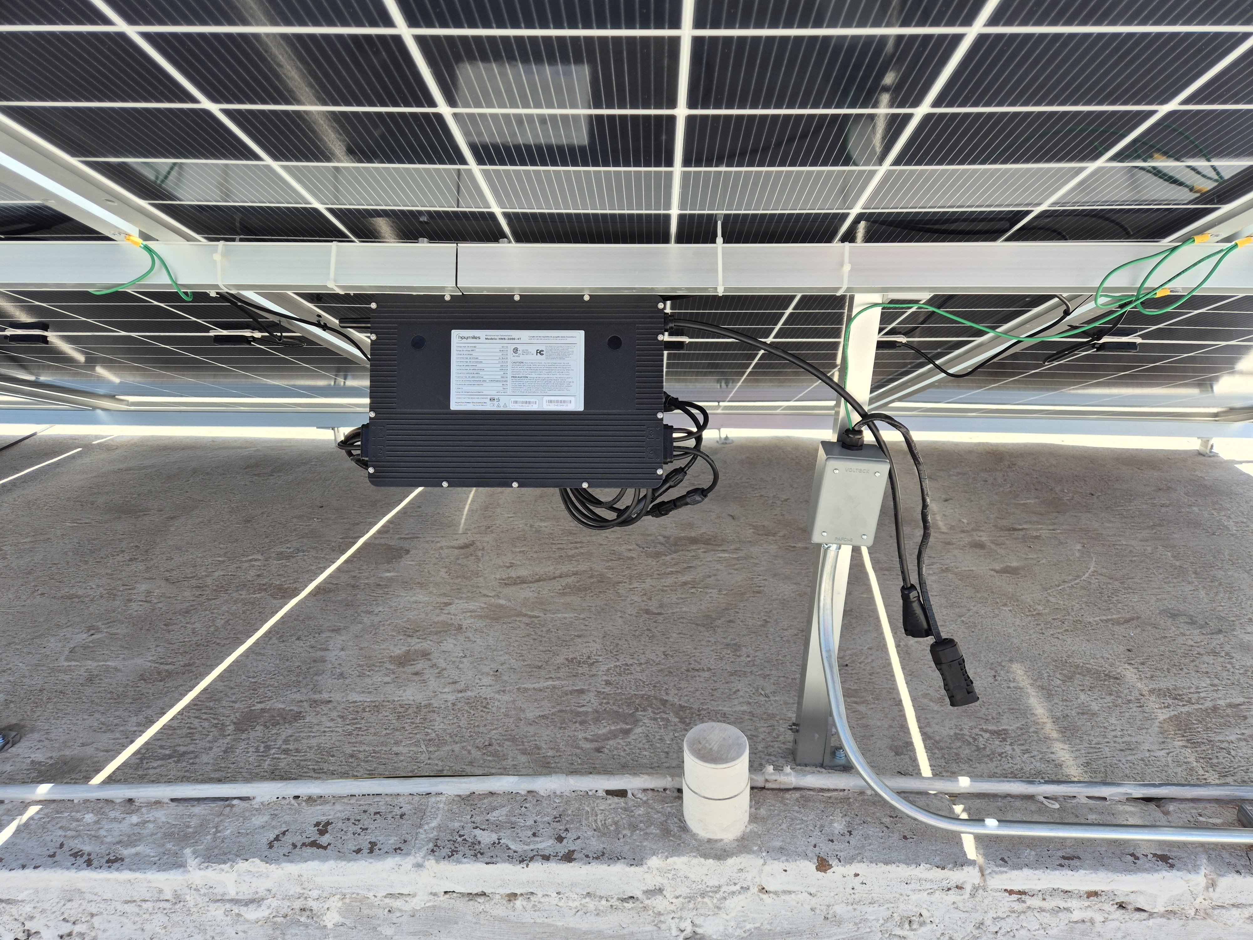 Microinversor Hoymiles montado bajo panel solar